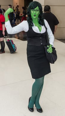 A woman cosplaying as She-Hulk striking a pose at a Comic Con.